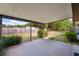 Covered patio showing the concrete flooring and view of the fenced backyard with grassy area and green foliage at 14555 Se 98Th Ave, Summerfield, FL 34491