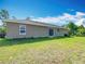 Backyard features green grass, a patio with sliding glass doors, and a view of the wooded area at 15640 Sw 48 Ave, Ocala, FL 34473