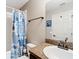 Neutral bathroom includes a shower with a blue curtain, a sink, and a toilet at 15640 Sw 48 Ave, Ocala, FL 34473