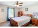 This bedroom features a ceiling fan, carpet flooring, and a spacious closet with a window at 15640 Sw 48 Ave, Ocala, FL 34473