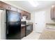 Well-lit kitchen featuring black appliances, plenty of cabinet space, and a double stainless steel sink at 15640 Sw 48 Ave, Ocala, FL 34473