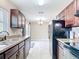 Spacious kitchen with dark wood cabinets, black appliances, and a view into the breakfast nook at 15640 Sw 48 Ave, Ocala, FL 34473