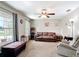 Comfortable living room showcasing natural light, a ceiling fan, and a relaxed seating area with a brown sofa at 15640 Sw 48 Ave, Ocala, FL 34473