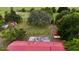 Aerial of a rural property with large yard, mature trees, red roof, and outbuildings at 16850 Se 19Th Ct, Summerfield, FL 34491