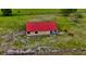 An aerial view of a charming farm with a barn and horses grazing in a lush green pasture at 16850 Se 19Th Ct, Summerfield, FL 34491