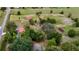 Drone eye view of red-roofed home nestled among green trees and outbuildings at 16850 Se 19Th Ct, Summerfield, FL 34491