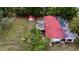 Aerial view of house with red roof, pool, mature trees, and outbuilding with fenced in yard at 16850 Se 19Th Ct, Summerfield, FL 34491