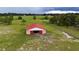 Barn with a red roof is perfect for storage and is located on a grassy field at 16850 Se 19Th Ct, Summerfield, FL 34491