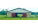 Rustic barn with a red roof, sliding red doors, and natural wood siding at 16850 Se 19Th Ct, Summerfield, FL 34491