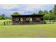 Rustic horse barn with weathered wood and visible framework standing in a grassy field at 16850 Se 19Th Ct, Summerfield, FL 34491