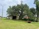 View of the barn surrounded by a lush green lawn, trees, and foliage at 16850 Se 19Th Ct, Summerfield, FL 34491