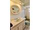 Small bathroom featuring a vanity, round mirror, toilet, and tub with shower at 16850 Se 19Th Ct, Summerfield, FL 34491