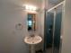 Bathroom featuring a standup shower, a pedestal sink, and a lighted mirror, creating a refreshing space at 16850 Se 19Th Ct, Summerfield, FL 34491