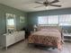 Bedroom with green walls, tile flooring, a decorated bed, white wood furnishings, and window views at 16850 Se 19Th Ct, Summerfield, FL 34491