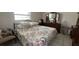This bedroom offers a window, comfortable bed with floral comforter, and wood furnishings at 16850 Se 19Th Ct, Summerfield, FL 34491