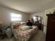 Cozy bedroom with a comfortable bed, dresser, and ample natural light, providing a relaxing atmosphere at 16850 Se 19Th Ct, Summerfield, FL 34491