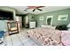 Bedroom featuring green walls, white tile flooring, a decorated bed, and access to the kitchen at 16850 Se 19Th Ct, Summerfield, FL 34491