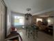 Bright dining area with a window overlooking a pool, tile floors, and a chandelier, creating an inviting ambiance at 16850 Se 19Th Ct, Summerfield, FL 34491