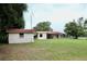A single story home with a red roof and multiple buildings is nestled in a well-maintained lawn at 16850 Se 19Th Ct, Summerfield, FL 34491