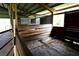 Interior of a horse stall with wooden walls, a metal gate, and concrete floor at 16850 Se 19Th Ct, Summerfield, FL 34491