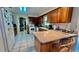 Open kitchen layout with wood cabinets, tile floors, and a counter with seating at 16850 Se 19Th Ct, Summerfield, FL 34491