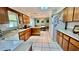 Bright kitchen with white appliances, wood cabinets and tile flooring, view to dining area at 16850 Se 19Th Ct, Summerfield, FL 34491
