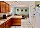 Kitchen with wood cabinetry, white appliances and tile flooring, opens to dining area at 16850 Se 19Th Ct, Summerfield, FL 34491