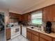 Functional kitchen featuring wood cabinets, modern appliances, and a sink with a window view, perfect for cooking at 16850 Se 19Th Ct, Summerfield, FL 34491