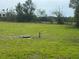 Large grassy land with scattered trees, well, and wooden fence in the background at 16850 Se 19Th Ct, Summerfield, FL 34491