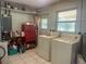 Functional laundry area with washer, dryer, red tool chest, and storage shelving at 16850 Se 19Th Ct, Summerfield, FL 34491