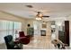 Comfortable living room featuring tile floors, ceiling fans, and natural light at 16850 Se 19Th Ct, Summerfield, FL 34491