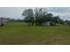 Large open pasture with trees, fencing, and outbuildings in the distance at 16850 Se 19Th Ct, Summerfield, FL 34491