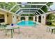 Enclosed pool area with a seating area and arched entryways at 16850 Se 19Th Ct, Summerfield, FL 34491