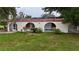 Home's rear exterior featuring stucco, archways, tile roof, and an enclosed pool area at 16850 Se 19Th Ct, Summerfield, FL 34491