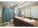 Bathroom featuring double sinks, a vanity, and a shower with a curtain, offering functionality at 171 Oak Cir, Ocala, FL 34472