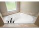 A corner bathtub with black fixtures and a window providing natural light, creating a relaxing bath space at 171 Oak Cir, Ocala, FL 34472