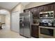 Bright kitchen featuring a stainless steel fridge, dark wood cabinets, modern appliances, and tiled floors at 171 Oak Cir, Ocala, FL 34472