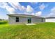 The house's backyard has healthy green grass, great sky view, and neutral exterior at 204 Emerald Loop Way, Ocala, FL 34472