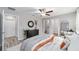Relaxing bedroom featuring a ceiling fan, a dresser with round mirror and access to the ensuite bathroom at 204 Emerald Loop Way, Ocala, FL 34472