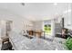Bright kitchen with stainless appliances, granite counters, breakfast bar and view of the dining area and back patio at 204 Emerald Loop Way, Ocala, FL 34472