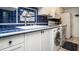 Kitchen featuring blue tile backsplash, stainless steel faucet, and in-unit laundry at 20820 River Dr # B25, Dunnellon, FL 34431