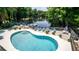 Community pool with lounge chairs and lake views at 20820 River Dr # B25, Dunnellon, FL 34431