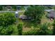 Aerial view highlighting a home's screened lanai and spacious, shaded backyard with mature trees at 21425 Sw Plantation St, Dunnellon, FL 34431