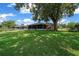Home's lawn with mature tree and screened lanai enhance the outdoor space, perfect for entertaining and relaxation at 21425 Sw Plantation St, Dunnellon, FL 34431
