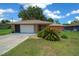 Charming single-story home featuring a stone accent garage and mature landscaping in the front yard at 21425 Sw Plantation St, Dunnellon, FL 34431