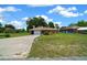 An eye-level shot of the home shows a charming exterior with a well-kept lawn and long driveway at 21425 Sw Plantation St, Dunnellon, FL 34431