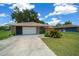 Front exterior of home featuring stone details, tidy landscaping and a spacious driveway at 21425 Sw Plantation St, Dunnellon, FL 34431