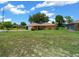 View of single-story home with large green front lawn with mature tree providing excellent shade at 21425 Sw Plantation St, Dunnellon, FL 34431