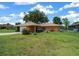 Attractive one-story home showcasing a tidy lawn, front plantings, and a stone detail on the facade at 21425 Sw Plantation St, Dunnellon, FL 34431
