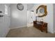 Open foyer featuring neutral carpet, decorative mirror, table, and seamless transition to the kitchen at 21425 Sw Plantation St, Dunnellon, FL 34431